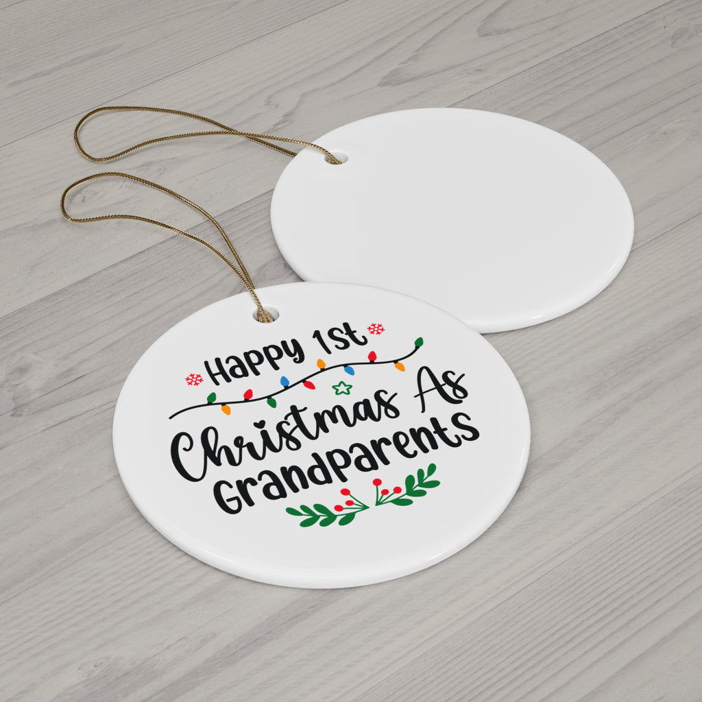Happy 1st Christmas As Grandparents ceramic ornament with gold string on a wood table